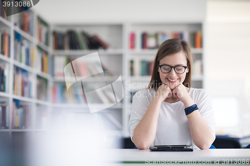 Image of female student study in school library, using tablet