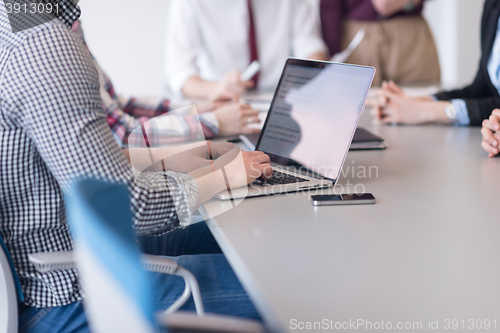 Image of close up of business man hands typing on laptop with team on mee