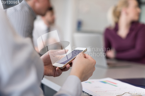 Image of close up of  busineswoman hands  using smart phone on meeting