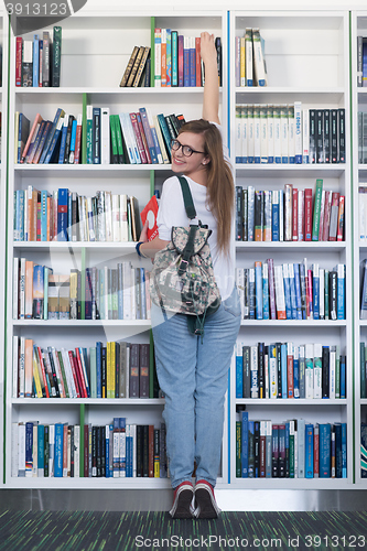 Image of famale student selecting book to read in library