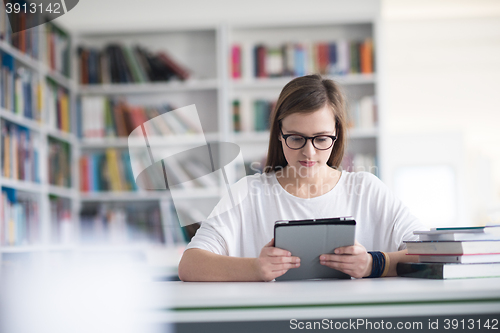 Image of female student study in school library, using tablet