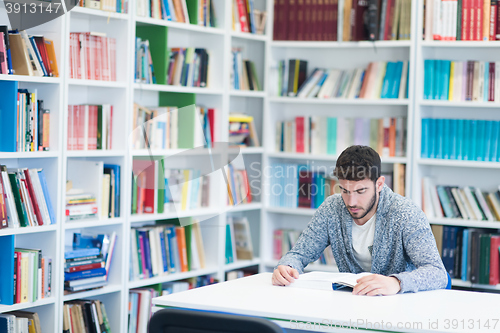 Image of portrait of student while reading book  in school library