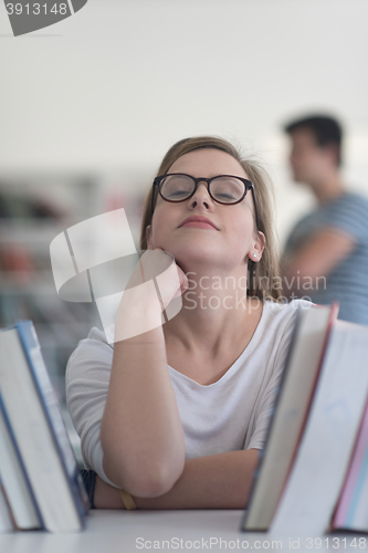 Image of portrait of famale student selecting book to read in library