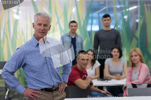 Image of portrait of  teacher with students group in background