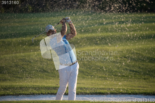 Image of golfer hitting a sand bunker shot on sunset