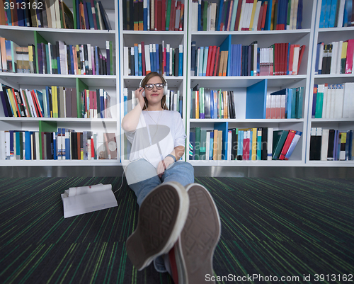 Image of female student study in library, using tablet and searching for 