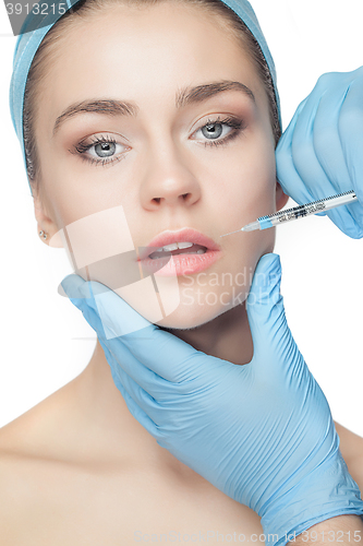 Image of Attractive woman at plastic surgery with syringe in her face