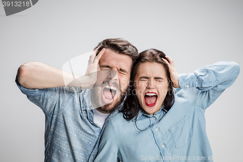 Image of Close up photo of angry man and woman touching their heads