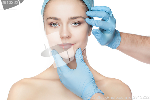 Image of Plastic surgery concept. Doctor hands in gloves touching woman face