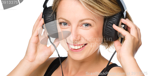 Image of Young woman enjoying music using headphones