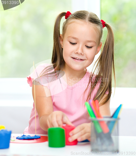 Image of Girl is having fun while playing with plasticine