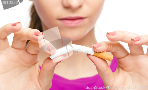 Image of Young woman is breaking a cigarette