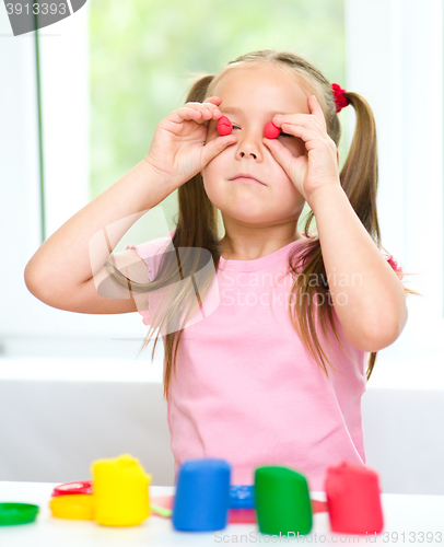 Image of Girl is having fun while playing with plasticine