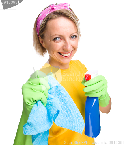 Image of Young woman with cleaning liquid and rag