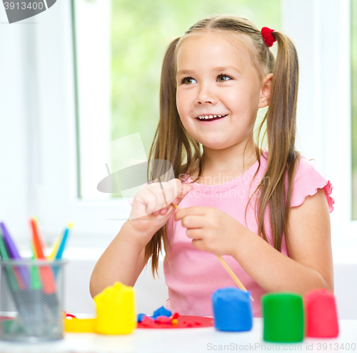 Image of Girl is having fun while playing with plasticine