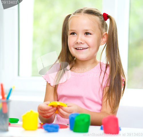 Image of Little girl is playing with plasticine