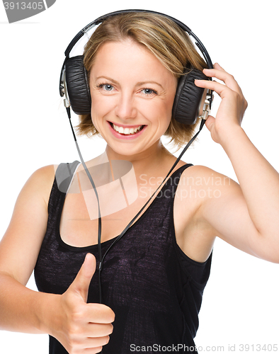 Image of Young woman enjoying music using headphones