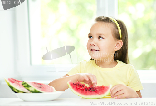 Image of Cute little girl is eating watermelon