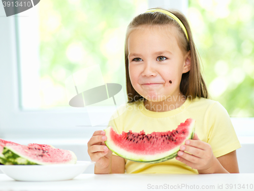 Image of Cute little girl is eating watermelon