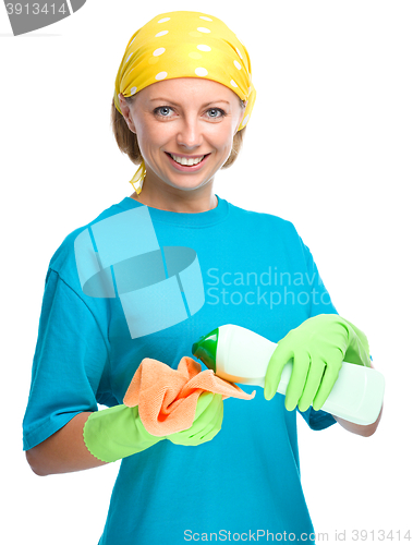 Image of Young woman with cleaning liquid and rag