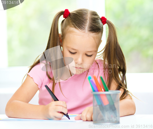 Image of Cute cheerful child drawing using felt-tip pen