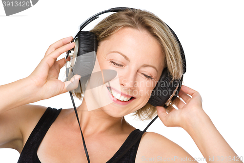 Image of Young woman enjoying music using headphones