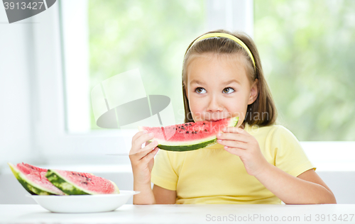 Image of Cute little girl is eating watermelon