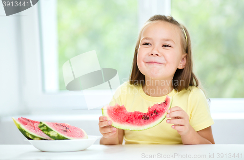 Image of Cute little girl is eating watermelon