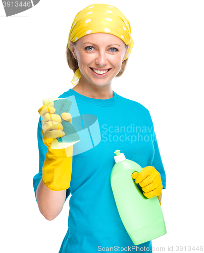 Image of Young woman with cleaning liquid and sponge