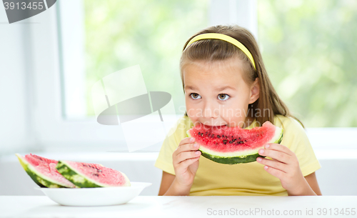 Image of Cute little girl is eating watermelon