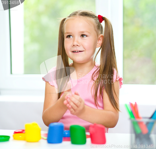 Image of Little girl is playing with plasticine