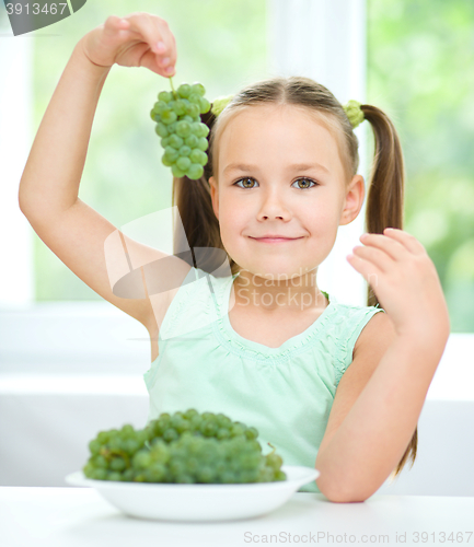 Image of Cute little girl is eating green grapes