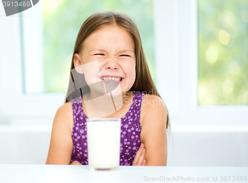 Image of Sad little girl with a glass of milk