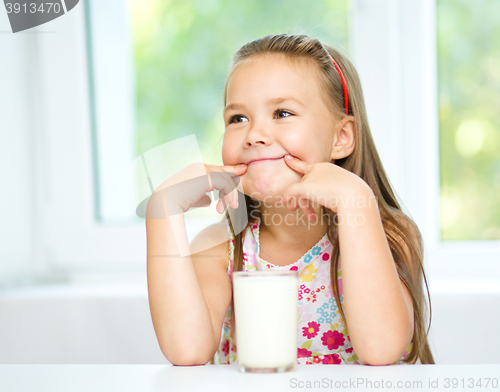 Image of Cute little girl with a glass of milk