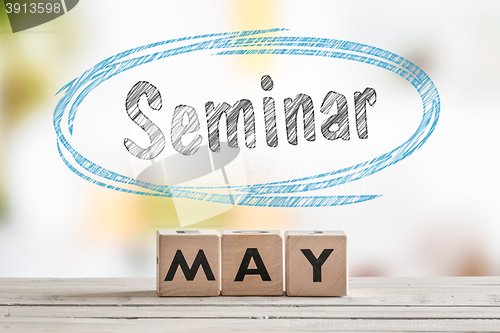 Image of May seminar sign on a wooden table