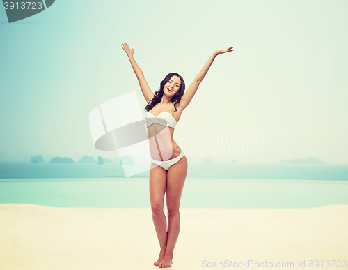 Image of happy young woman in white bikini swimsuit dancing