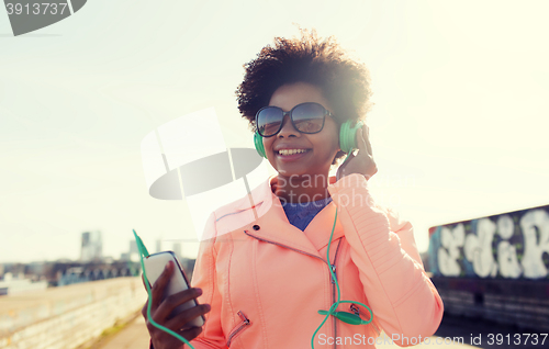 Image of happy young woman with smartphone and headphones