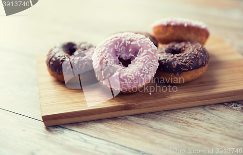 Image of close up of glazed donuts pile on wooden table