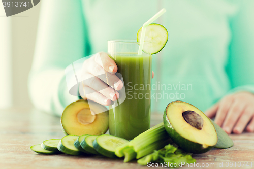 Image of close up of woman hands with juice and vegetables