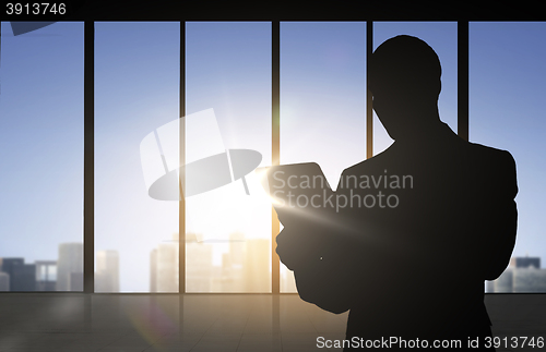 Image of silhouette of businessman with tablet pc at office