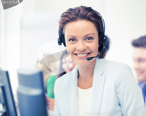 Image of helpline operator with headphones in call centre