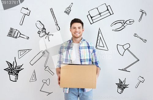 Image of smiling young man with cardboard box at home