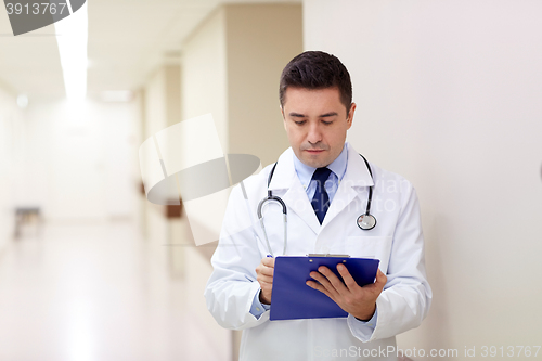 Image of doctor with clipboard at hospital corridor