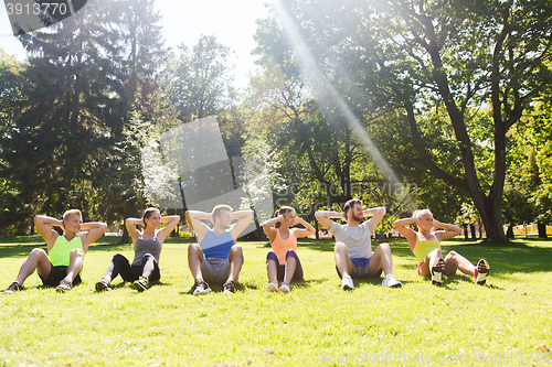 Image of group of friends or sportsmen exercising outdoors