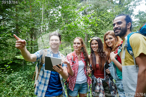 Image of happy friends with backpacks and tablet pc hiking