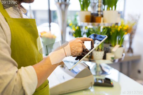 Image of close up of man with tablet pc at flower shop