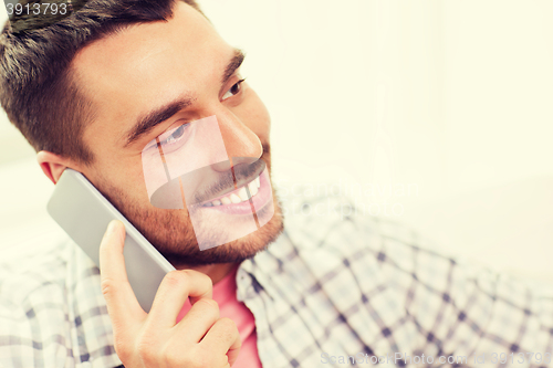 Image of smiling young man calling on smartphone