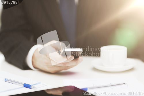 Image of businessman with smartphone reading news