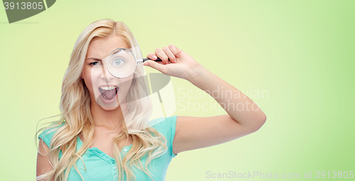 Image of happy young woman with magnifying glass