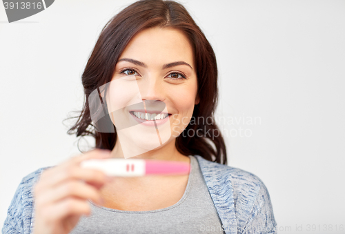 Image of happy smiling woman holding home pregnancy test